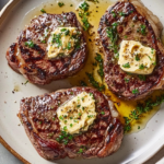 Juicy sirloin steak topped with rich garlic butter, served on a plate with fresh herbs.