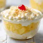 A vibrant bowl of easy pineapple dessert, garnished with fresh pineapple chunks and shredded coconut, ready to serve.